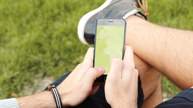 Homem manuseando o smartphone