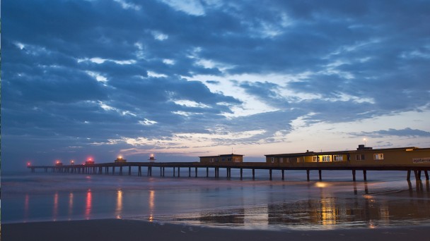 Plataforma de pesca de Tramanda&iacute;, Rio Grande do Sul, ao entardecer, sob c&eacute;u nublado.